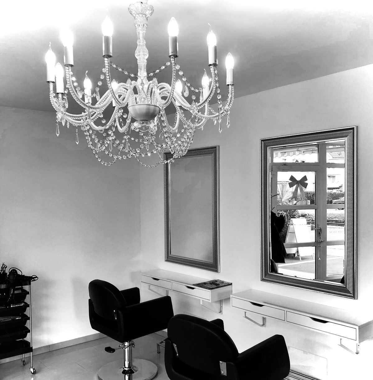 Blick in den Salon Coiffure Agnesa — Frisierplätze, Spiegel und Deckenleuchter